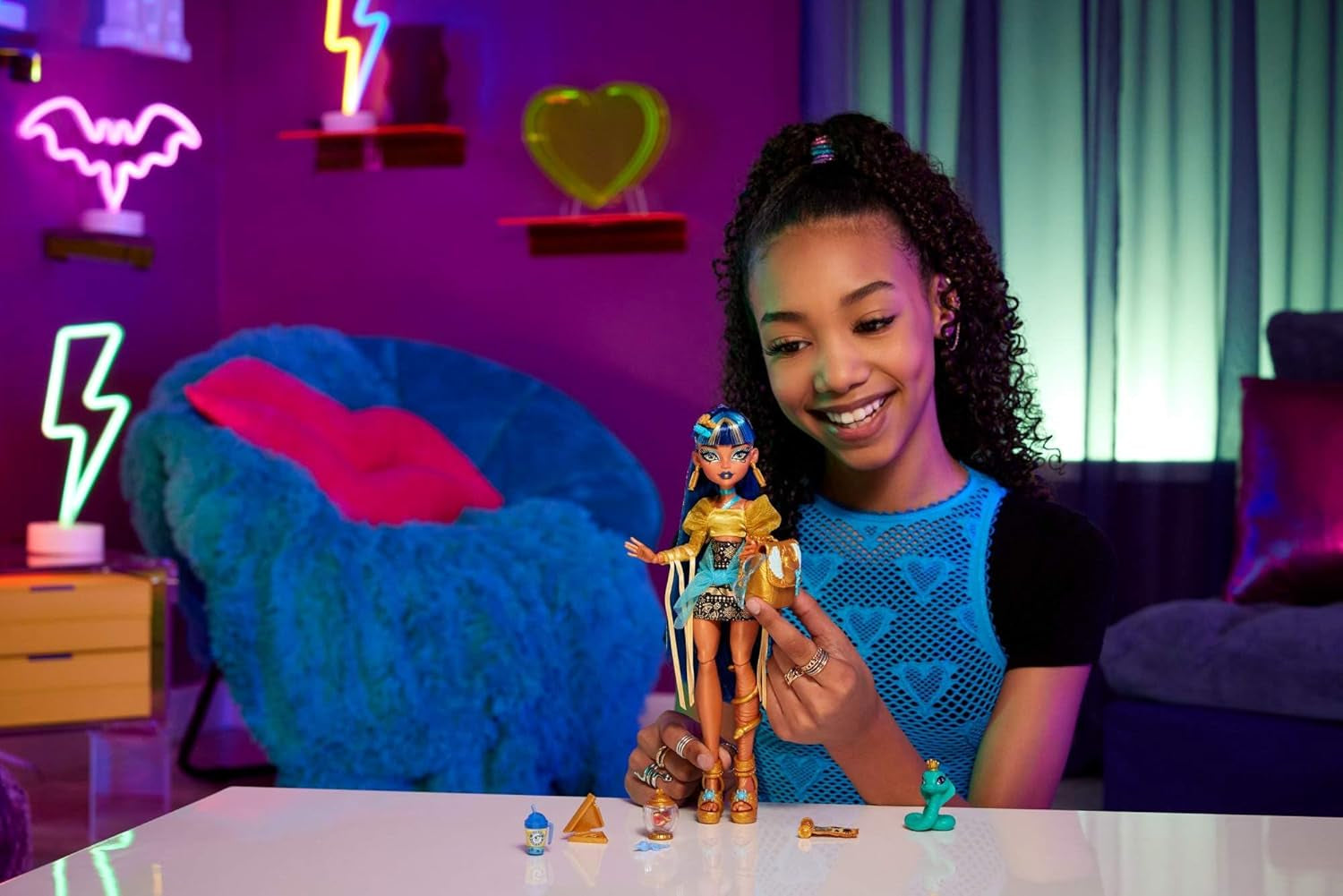 Monster High Cleo De Nile-Puppe in einer goldenen Bluse und einem mehrlagigen Rock, inklusive der Hissette-Kobra und Accessoires wie einer Schultasche, einem Snack und einer Rolle Toilettenpapier, HXH74